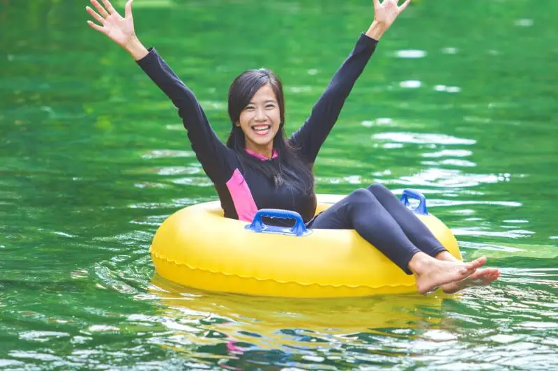 woman smiling while river tubing in the blue ridge mountains