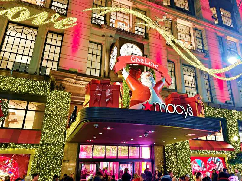 shop facade of macys with giant santa above doors and wreatsh around the door