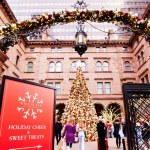 old hotel from outside with arch with lights and garlands and large christmas tree