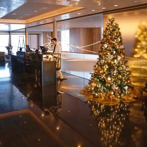 hotel front desk with christmas tree beside it