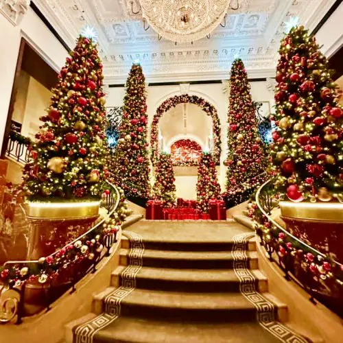 staircase with trees and other christmas decorations at the peninsula hotel in nyc